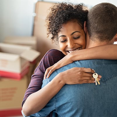 two people hugging one person holding keys 