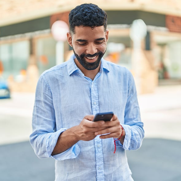 man standing outside holding mobile phone