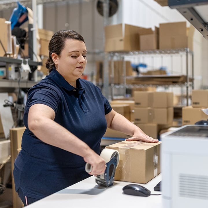 warehouse worker taping a box 