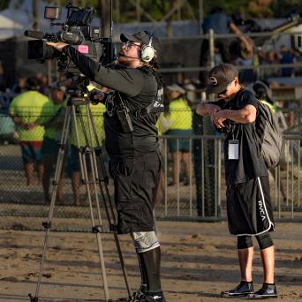 two people filming outside using professional filming equipment