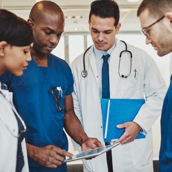 huddle of medical healthcare workers looking at a folder