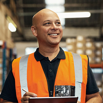 worker holding a clipboard wearing a reflective vest