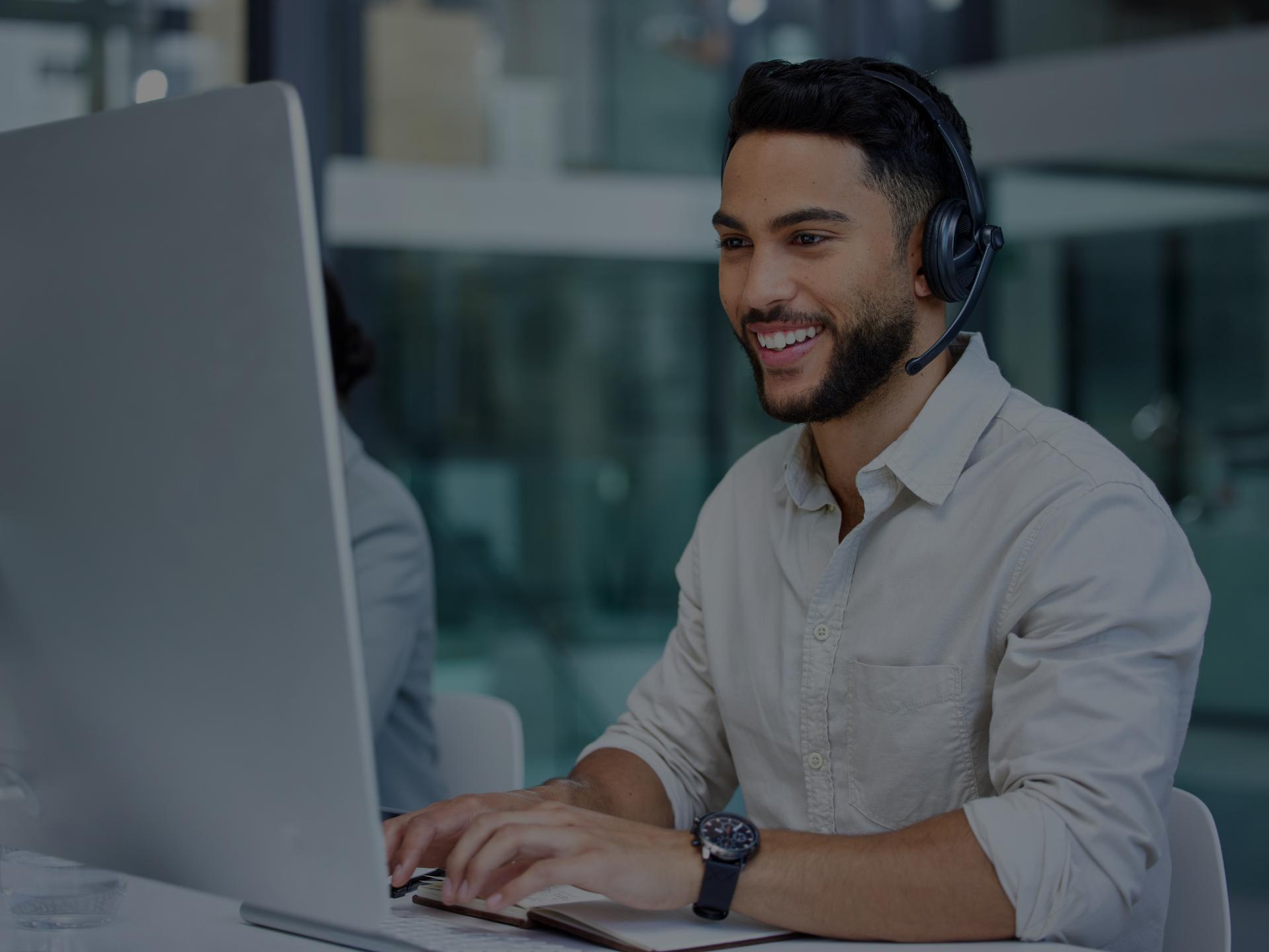 An office worker with headphones on, focusing on his work.