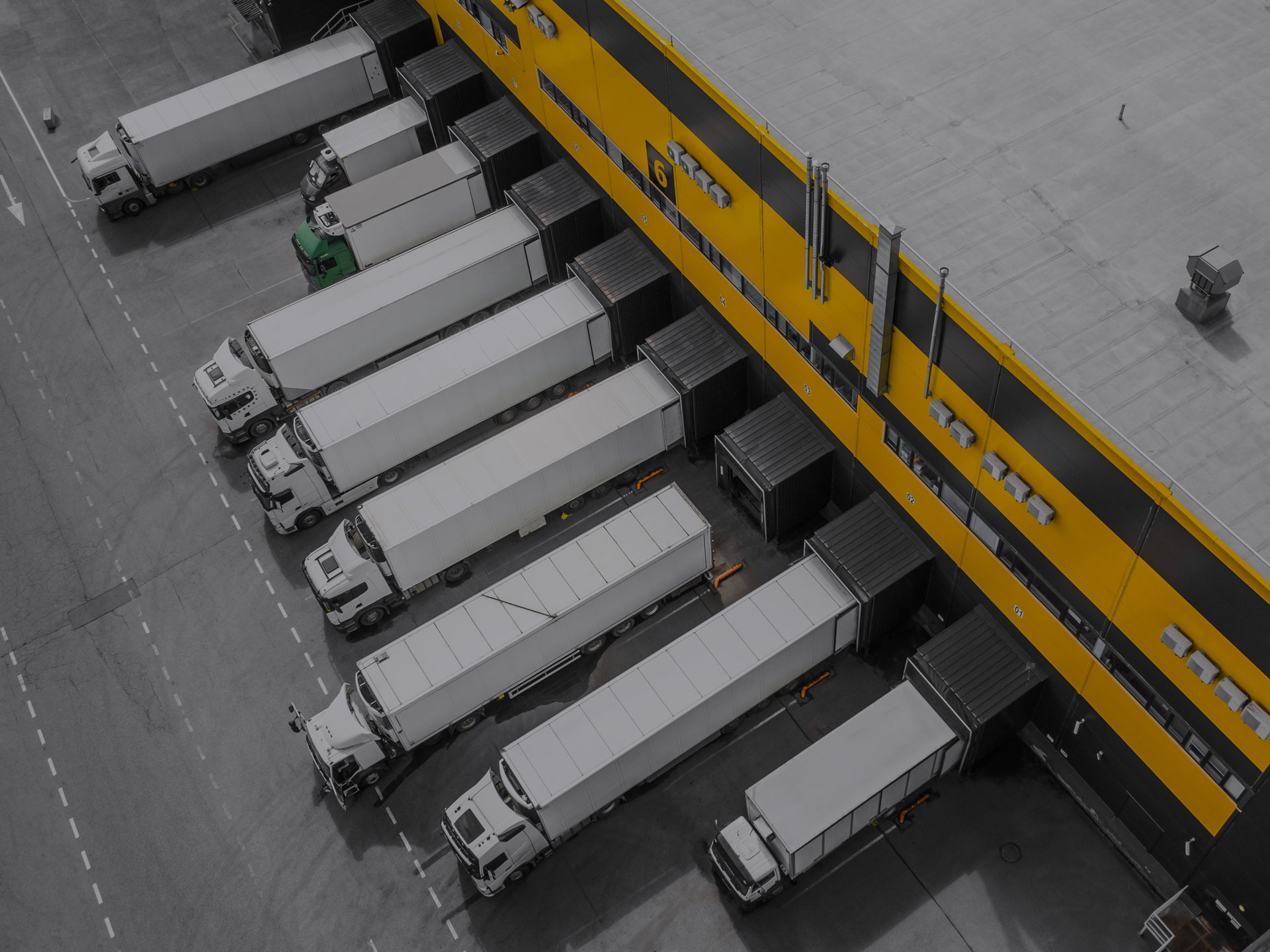 White trucks lined up at a loading dock. 