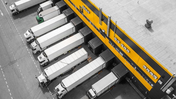 White trucks lined up at a loading dock. 