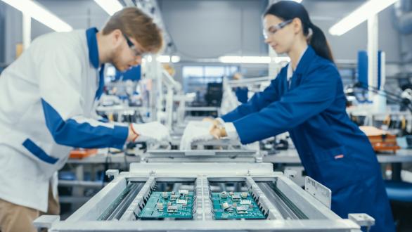 Two workers working on technology hardware. 